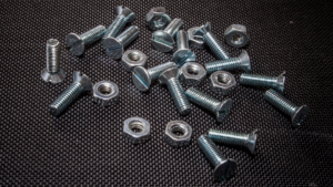 Key Takeaways: Passivation Creates A Double-Edged Sword: The process that protects against corrosion may leave threads vulnerable to galling without proper preventive measures. Prevention Requires A Multi-Layered Approach: Lubrication, coating selection, thread design, and installation control must work together. Compliance Documentation Is Non-Negotiable: Aerospace and defense programs demand audit-ready verification of galling prevention protocols. How To Prevent Galling After Passivation On Stainless Steel Threads Galling on stainless steel threads is one of those problems that catches teams off guard, particularly after passivation, when the very process applied to protect the surface inadvertently increases the risk of thread seizure. It is a paradox that frustrates engineers and procurement teams alike; the treatment meant to extend component life creates the conditions for premature failure. Valence Surface Technologies, the world's largest independent aerospace surface finishing company, processes stainless steel components to the strictest aerospace standards, with deep expertise in passivation processes and the downstream effects that impact fastener performance. In this piece, we will cover what causes galling after passivation, why stainless steel is particularly vulnerable, and the most effective strategies for preventing it on threaded fasteners. What Is Galling And Why Does It Occur On Stainless Steel Threads? Galling is cold welding between metal surfaces under pressure and friction. When stainless steel threads engage, microscopic surface asperities contact, generate heat, and create localized adhesion. Unlike wear or abrasion, galling involves actual material transfer between mating surfaces, leading to progressive thread destruction. Understanding how to prevent galling threaded fasteners starts with recognizing the surface chemistry and mechanical conditions that make stainless steel uniquely susceptible. The Mechanics Behind Thread Seizure Austenitic stainless steels are prone to adhesive wear due to their ductility, work-hardening behavior, and tendency to form strong metallic junctions under pressure and during sliding. During tightening, contact pressure exceeds the material's yield strength at microscopic points. The protective oxide layer breaks down under shear stress, exposing fresh metal that instantly bonds with the mating surface. Continued rotation tears material from one surface and deposits it on the other, building up until the fastener locks completely. Material Properties That Increase Galling Risk Both 304 and 316 stainless steels are susceptible to galling. These austenitic alloys exhibit high ductility and work-hardening characteristics, meaning threads deform rather than shear cleanly under stress. The strain-hardening effect progressively increases surface hardness during installation, creating even stronger adhesive bonds. Relative galling behavior depends on hardness, surface finish, lubrication, thread geometry, and assembly conditions rather than alloy grade alone. Alt Image Text: What Is Galling And Why Does It Occur On Stainless Steel Threads? The Relationship Between Passivation And Galling On Stainless Steel Passivation of stainless steel is commonly specified for aerospace corrosion-resistant steel components, often using AMS 2700 when required by drawing, purchase order, or program specification. This treatment chemically removes free iron and surface contaminants while supporting the formation of a chromium-rich passive film. However, passivation fundamentally alters surface characteristics, requiring additional galling-prevention measures. For programs managing stainless steel galling passivation risks, understanding what happens at the surface level after treatment is essential to building an effective prevention strategy. How Surface Chemistry Changes After Passivation Passivation chemically cleans the surface and supports the formation of a chromium-rich passive film, but it does not necessarily smooth the surface or eliminate topographical variation. Freshly cleaned and passivated stainless surfaces may have fewer contaminant films separating mating threads; however, the passive oxide layer itself is intended to reduce chemical reactivity and improve corrosion resistance. Without subsequent protective treatment or lubrication, clean metal-to-metal contact can increase adhesion potential during thread engagement. The Clean Surface Challenge Clean surfaces can experience greater true metal-to-metal contact area than contaminated or pre-lubricated surfaces. When passivated threads engage uniformly across the entire thread form, distributed contact increases total adhesive force compared to rougher surfaces where contact occurs only at peak points. Why Passivated Stainless Steel Fasteners Are More Susceptible To Galling The timing of passivation in the manufacturing sequence creates inherent vulnerability. Parts are typically passivated as a final chemical operation after machining and deburring. This means threads receive no subsequent protective treatment unless specifically applied as a separate finishing step. Thread Tolerance Impact Aerospace specifications demand tight thread tolerances for structural integrity and vibration resistance. Class 3A/3B threads provide tighter-tolerance fits than Class 2A/2B and can increase sensitivity to surface condition, lubrication, and assembly control. Combined with passivation's clean surface condition, this geometric precision can maximize contact pressure and galling risk without proper preventive measures. Alt Image Text: Passivated Stainless Steel Fasteners Common Causes Of Galling After Passivation In Aerospace Applications Multiple operational factors compound passivation-related galling risk in mission-critical manufacturing. Installation Speed and Technique Variations Improperly controlled power-tool installation, especially at high speed, poor alignment, or inadequate torque control, can increase heat and friction, raising the risk of galling. Operator technique variations across shifts introduce quality inconsistencies even with identical fasteners. Environmental Contamination Post-Passivation If handling, packaging, storage, or transport controls are inadequate, passivated parts may accumulate films or particulates that affect lubrication and assembly performance. Moisture, oils, and contaminants alter surface chemistry unpredictably, rendering engineered galling-prevention measures ineffective. Material Pairing Issues Mating passivated stainless fasteners with dissimilar materials, aluminum structures, titanium fittings, or other stainless grades creates galvanic and mechanical compatibility challenges. Each combination exhibits unique friction characteristics and load distribution patterns affecting galling susceptibility. How To Prevent Galling On Passivated Stainless Steel Threaded Fasteners Systematic prevention requires addressing surface treatment, mechanical design, and assembly procedures simultaneously. Pre-Passivation Surface Preparation Thread surface condition entering passivation significantly impacts final assembly performance. Deburring quality, machining marks orientation, and pre-cleaning effectiveness set baseline conditions. Parts should be properly cleaned before passivation because oils and organic residues can interfere with the process. Controlled Passivation Processing Process variables, acid concentration, temperature, and immersion time must remain within their specified ranges. We maintain real-time process monitoring and statistical process control across all chemical operations, ensuring consistent oxide layer formation. To learn more about how we manage this process, explore our full range of services built around aerospace-grade surface finishing requirements. Thread Design Optimization Where design authority permits, specifying Class 2A/2B threads instead of Class 3A/3B provides additional clearance that can reduce contact pressure sensitivity. Thread relief grooves, reduced engagement length, and optimized thread-form modifications may reduce the probability of galling without compromising joint integrity, subject to design approval. Coating And Lubrication Solutions That Reduce Galling Risk After Passivation Post-passivation surface treatments provide mechanical separation between mating threads. Dry Film Lubricants Molybdenum disulfide, PTFE, and graphite-based coatings can reduce galling risk by lowering friction and separating surfaces. These treatments must withstand aerospace environmental requirements while maintaining dimensional tolerances. Application must occur post-passivation as a separate finishing operation. Selection must be application-specific, taking into account temperature, humidity, vacuum exposure, and contamination restrictions. Silver and Copper Plating Thin, precious-metal deposits provide sacrificial layers with superior lubricity compared to stainless substrates. Silver plating per AMS 2410 is a recognized anti-galling and conductive surface treatment, though electrical bonding performance still requires design- and process-specific verification. Where silver plating is not suitable, our nickel plating capabilities offer an alternative protective layer with proven wear resistance and compatibility across a wide range of aerospace fastener applications. Anti-Seize Compounds Thread lubricants containing metallic particles or solid lubricants reduce friction coefficients during installation. Selection must consider temperature exposure, chemical compatibility, and contamination concerns in assembled systems. For applications requiring maximum surface durability, our chrome plating services provide an additional hard-surface option that can be evaluated alongside anti-seize strategies to deliver the most effective protection for mission-critical threaded assemblies. Aerospace specifications often restrict permissible compounds based on program requirements. Alt Image Text: Silver Plating Final Thoughts Preventing galling after passivation on stainless steel threads demands technical precision and systematic process control. The surface chemistry changes that protect against corrosion may leave threads vulnerable to adhesive wear, a reality that aerospace manufacturers must address through engineered finishing sequences, appropriate coating selection, and rigorous quality verification. Success requires understanding the interplay between metallurgy, surface treatment, mechanical design, and assembly procedures. Valence's purpose-built platform delivers the integrated capability, technical depth, and production capacity that mission-critical programs require. Our consolidated approach eliminates the vendor coordination challenges that compromise quality outcomes while maintaining the compliance rigor that aerospace manufacturing demands. Frequently Asked Questions About How To Prevent Galling After Passivation On Stainless Steel Threads How does passivation impact the surface properties of stainless steel and its susceptibility to galling? Passivation creates more chemically stable surfaces with enhanced corrosion resistance but reduced natural lubricity. These surface changes, combined with high thread loads and metal-to-metal contact, increase the potential for adhesive wear if proper lubrication and assembly controls are not implemented. What industry standards and compliance requirements govern threaded components in defense and space manufacturing? Aerospace threaded components must comply with ASTM A967 for passivation, AMS 2700 for processing requirements, ASME B1.1 for thread specifications, and program-specific specifications addressing galling prevention and assembly procedures. What pre-passivation strategies are most effective for reducing galling risk in mission-critical applications? Thread tolerance optimization, surface finish specification control, and design reviews addressing engagement geometry reduce galling risk before passivation processing begins. How should lubrication be applied before passivation to prevent galling without compromising surface treatment? Lubricants must be applied after passivation is complete to avoid chemical interference; pre-passivation lubrication contaminates the treatment chemistry and prevents proper oxide layer formation. Which testing protocols should be used to verify galling-prevention measures before production release? Torque-tension testing, thread engagement cycling, and accelerated wear evaluation under representative assembly conditions verify the effectiveness of galling prevention before a full production commitment. How can organizations implement audit-ready documentation systems to demonstrate compliance? Unified Quality Management Systems capturing passivation parameters, coating specifications, assembly procedures, and verification testing results in traceable formats satisfy aerospace audit requirements and regulatory standards.